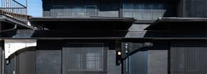 A modern building facade with metal panels and a blurred background.