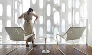 Modern interior space with transparent glass walls showcasing a coastal view.