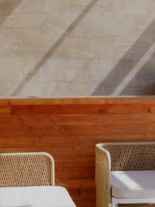 A modern interior scene featuring woven furniture with white table tops.
