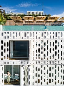 A modern pool deck with glass railings and wooden flooring