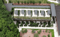 A modern residential exterior with timber and brick construction, surrounded by greenery.