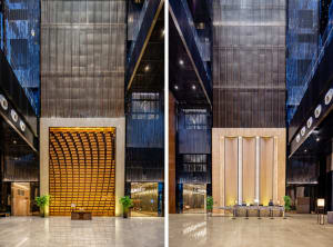 A modern lobby with metallic walls, a reception desk, and large windows.