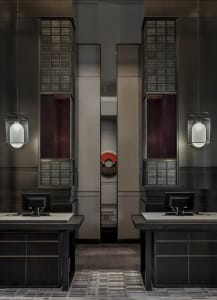 Modern, minimalist reception desk featuring a black metallic finish and wooden elements.