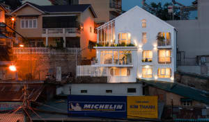 A modern residential building illuminated at night, featuring wooden balconies and glass windows.