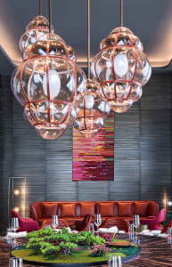 Modern restaurant interior with hanging glass chandeliers and a centerpiece display.