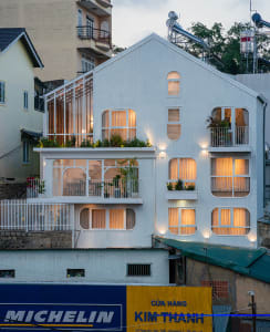 A white-paneled building with large windows and balconies.