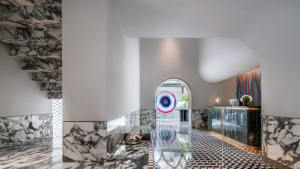 Interior view of a modern hotel lobby featuring marble flooring and a reception desk.