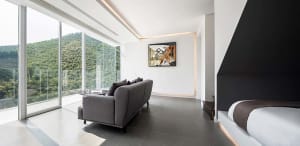 A modern living room with a large glass wall overlooking a scenic landscape.