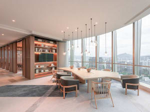 Modern office conference room with contemporary wood accents and floor-to-ceiling windows overlooking a cityscape.