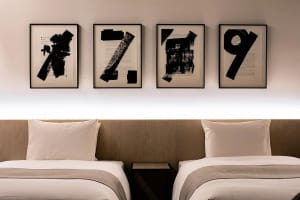 Minimalist bedroom with black numbers on the wall and soft, neutral bedding.