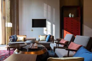 Contemporary living room with modern furniture, including sofas, chairs, and a coffee table with decorative items.