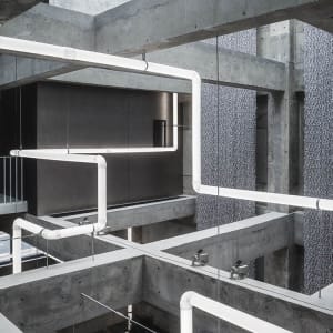 Modern interior space featuring concrete pipes and minimalist design elements.