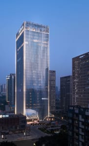 A modern office building with glass and metal exterior featuring a prominent Tower-like structure.