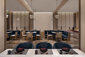 Modern restaurant interior with blue seating and wooden finishes.