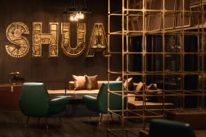 A modern industrial-style lobby featuring metallic decor and seating arrangements with leather accents.