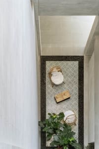 Minimalist living space decorated with wooden furniture, stone tiles, and woven fiber elements.
