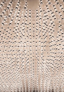 A modern chandelier made of glass with intricate wireframe design.