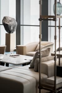 Modern minimalist living room featuring leather furniture, marble coffee table, and metal accents.