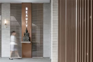 Spa interior with wooden walls, metal accents, and a sign reading 'Beauty'.