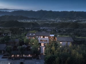 Traditional brick villa surrounded by lush greenery, featuring a modern interior design with large windows and natural light.