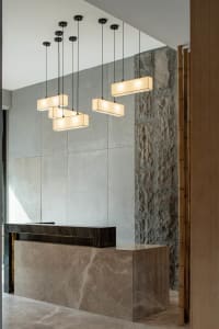 A modern lobby with concrete walls and a reception desk made of the same material, featuring a minimalist design with hanging