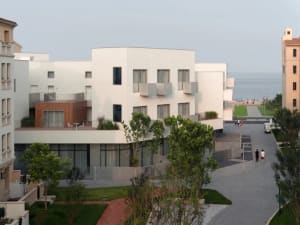 Modern apartment building with concrete and wood exterior and large windows.