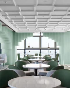 A contemporary restaurant interior featuring modern design elements like green acrylic columns and a coffered ceiling.