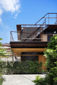 Modern building with metallic structure and greenery around it.