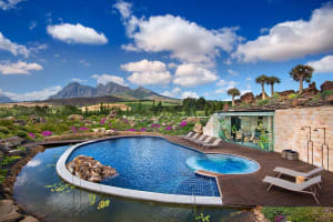 A modern pool setting with stone surroundings and a scenic landscape.