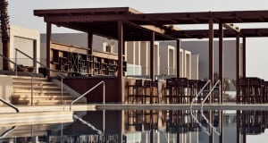A modern architectural wooden pool bar featuring high stools and a bar counter.