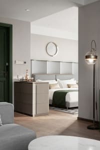 Modern bedroom featuring minimalist furniture, white walls, and a stylish headboard.