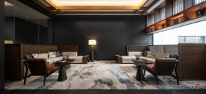 A modern living room featuring white sofas with textured fabric, dark wooden furniture, and a patterned rug.