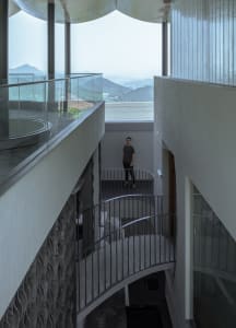 A modern interior design featuring concrete and glass materials