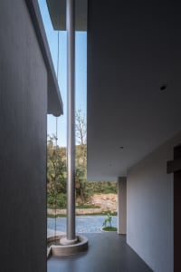 Modern residential corridor featuring concrete and stone materials with an exterior view.