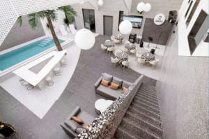 Modern interior space featuring concrete flooring with a pool and seating areas.