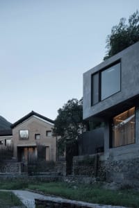 A minimalist house featuring a modern concrete frame and sleek windows.