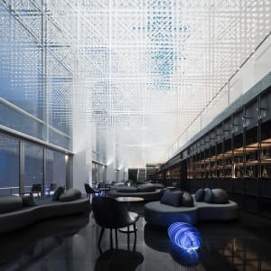 Modern business lobby featuring glass walls and metallic structural elements.