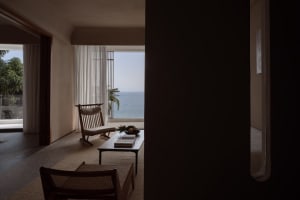 Modern living room with glass railing overlooking the ocean.