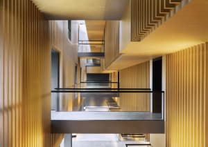 A modern interior corridor featuring wooden walls and lighting.