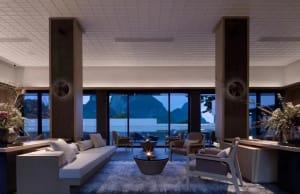 Modern lounge area with glass walls, comfortable seating, and a cozy atmosphere.