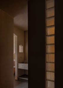 Modern residential space featuring architectural glass bricks and concrete elements.