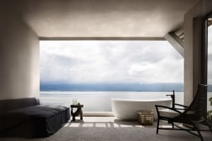 A minimalist residential interior with concrete elements and a stunning sea view.