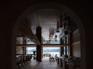 A modern bar lounge decorated with concrete walls and wooden furniture.