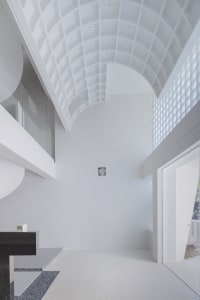 Minimalist interior with white concrete walls, glass walls, and metal elements.
