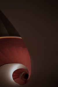 Modern red spiral staircase with warm lighting inside