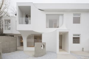 A modern white house featuring concrete and glass materials.