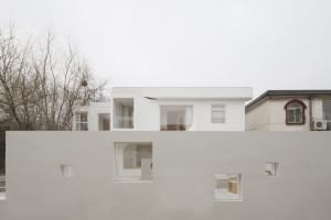 Modern minimalist house with a white exterior and concrete elements.
