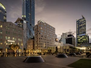 A modern cityscape featuring brick and glass buildings in an urban setting.