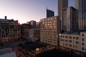 A bustling urban landscape featuring modern architectural buildings with brick, glass, and steel exteriors.