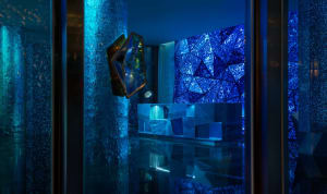 A minimalist hotel lobby featuring glass walls and geometric designs.